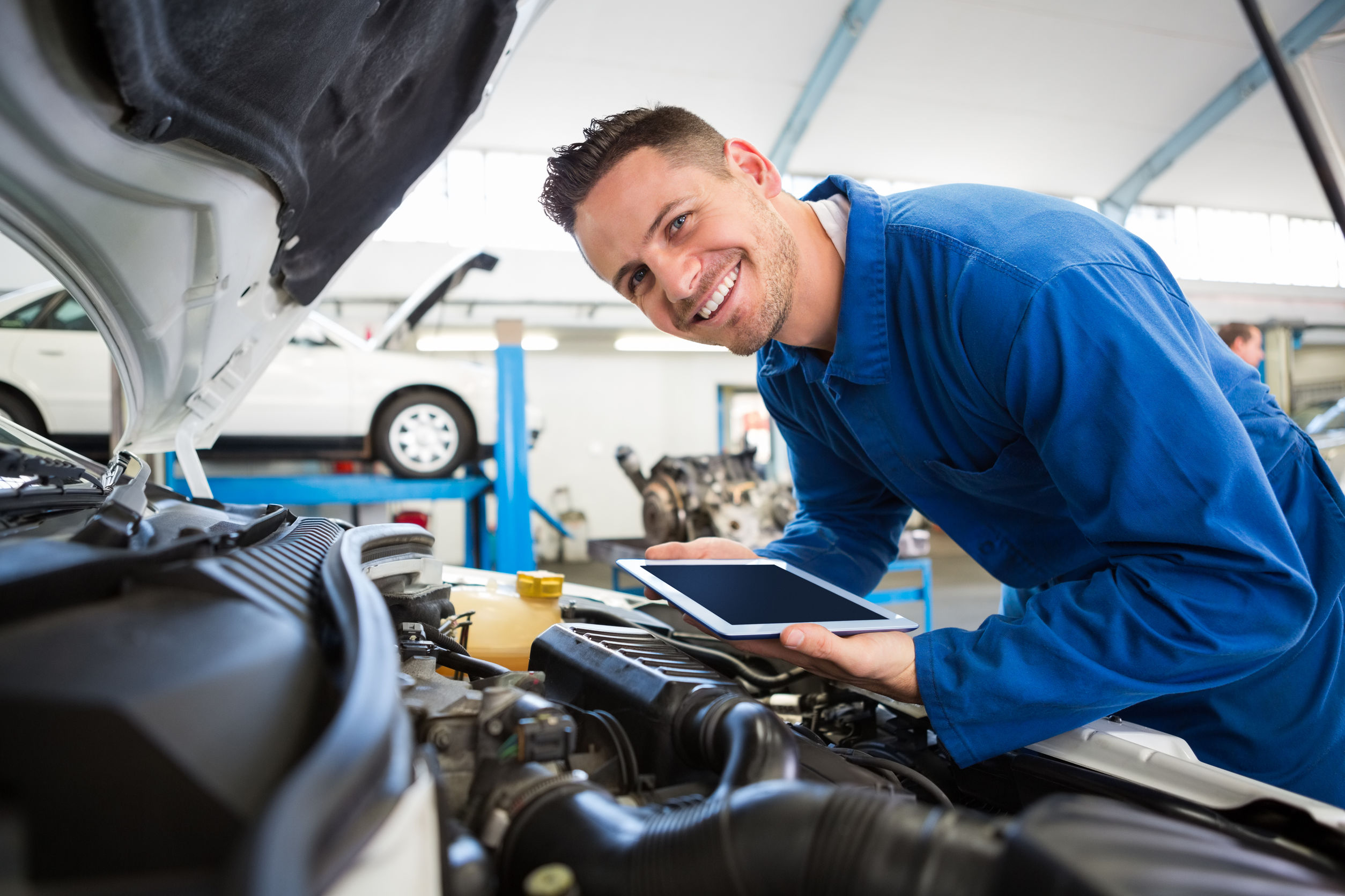 Mechanic using tablet on car at the repair garage